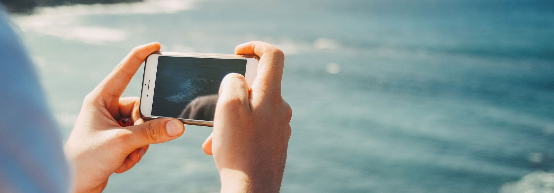 person taking photo of ocean